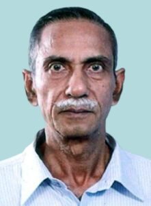 An old man with a mustache and a blue shirt.