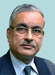 An indian man wearing glasses and a suit.